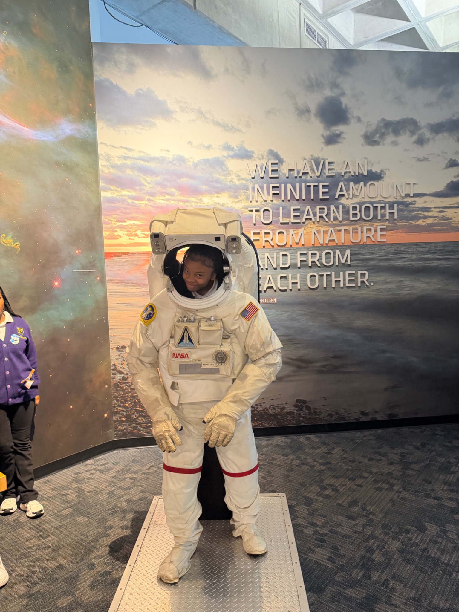 A student exploring an astronaut suit exhibit